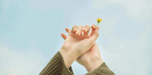 Image of woman's hands holding a flower to celebrate life