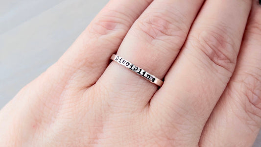Image of ring on hand, stamped with Discipline for Word of the Year