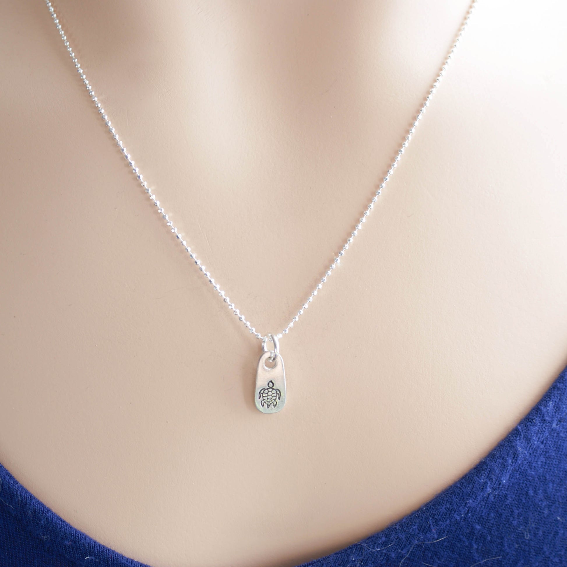 Silver sea turtle necklace in artisan pewter on neck