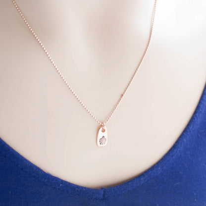 Rose gold necklace stamped with a turtle on neck