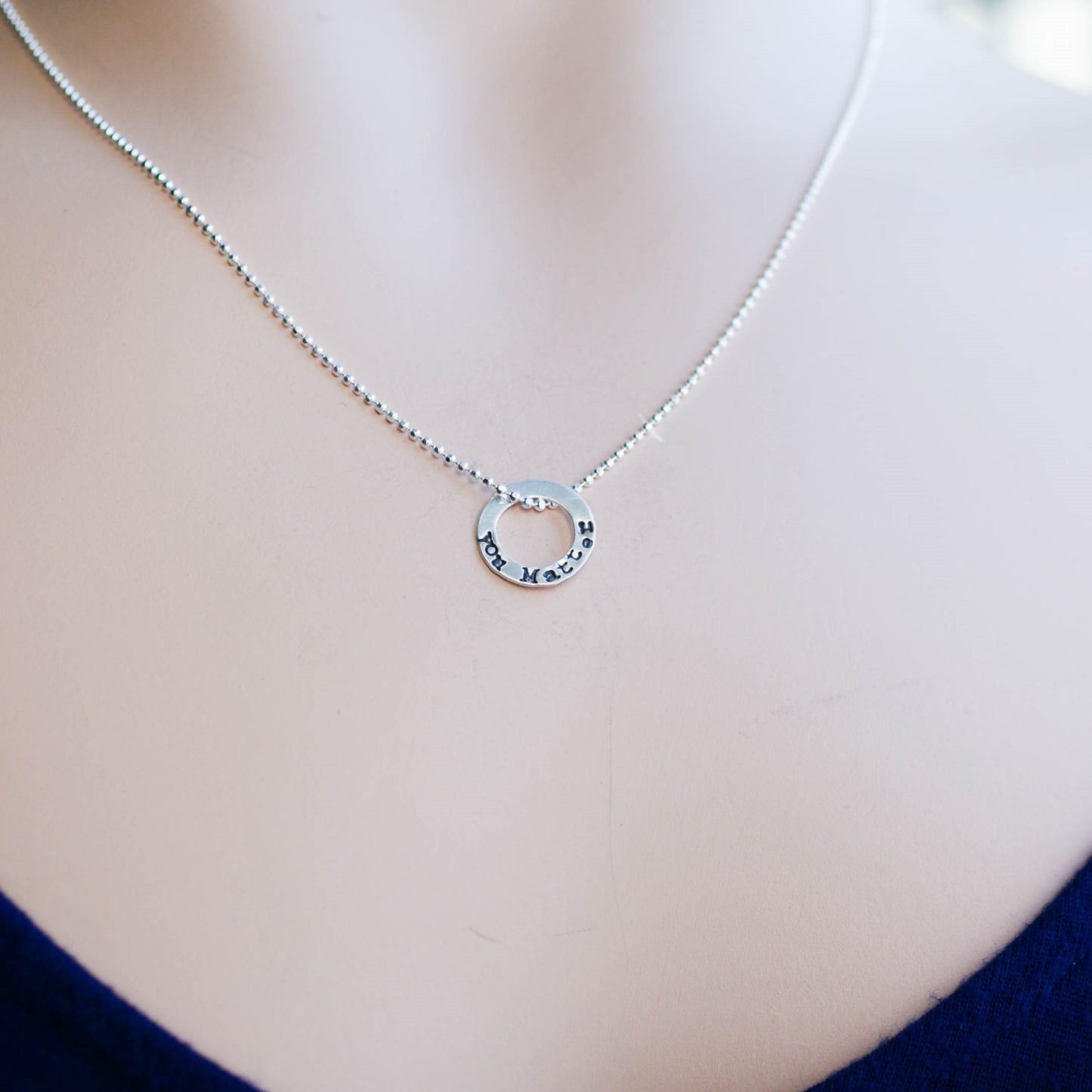 Tiny circle necklace in sterling silver stamped with You Matter on neck