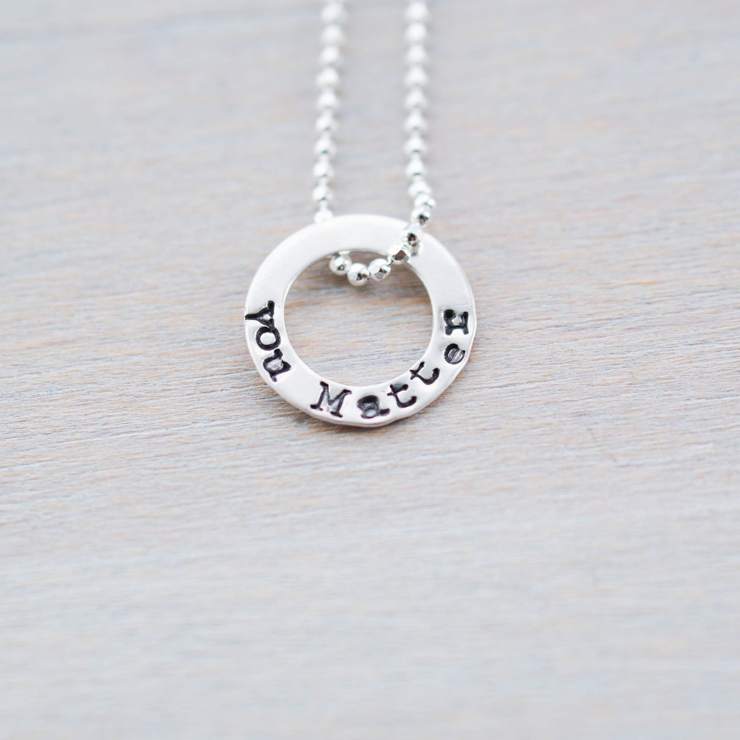 Tiny circle necklace in sterling silver stamped with You Matter