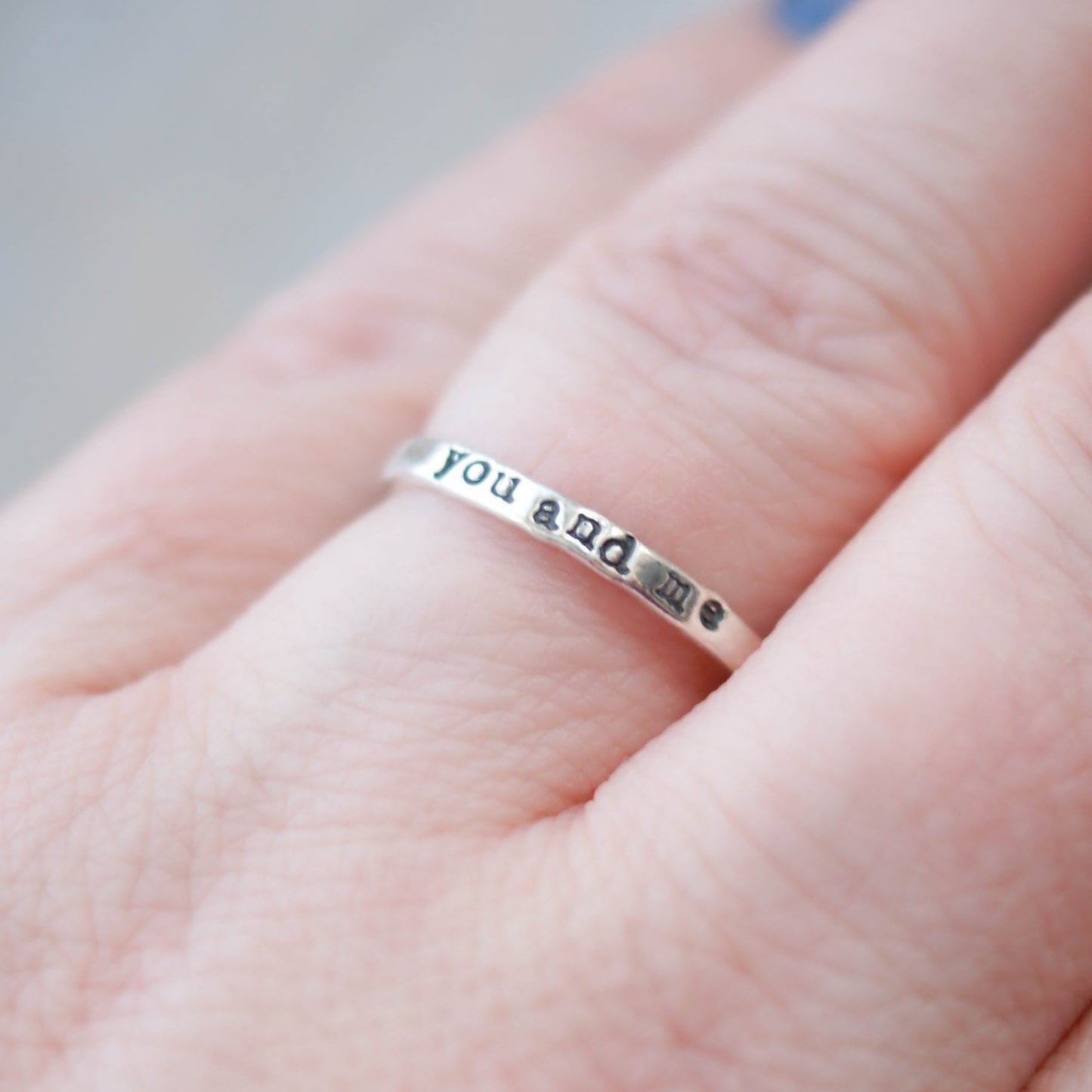 Skinny sterling silver ring stamped with you and me on hand
