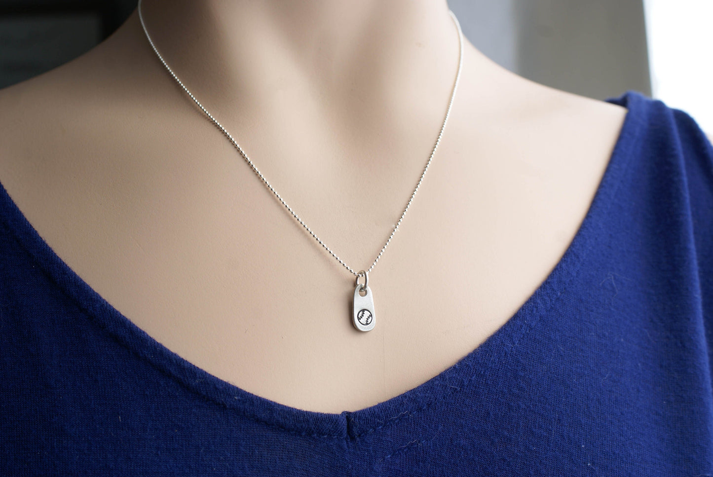 Silver baseball necklace in artisan pewter on neck
