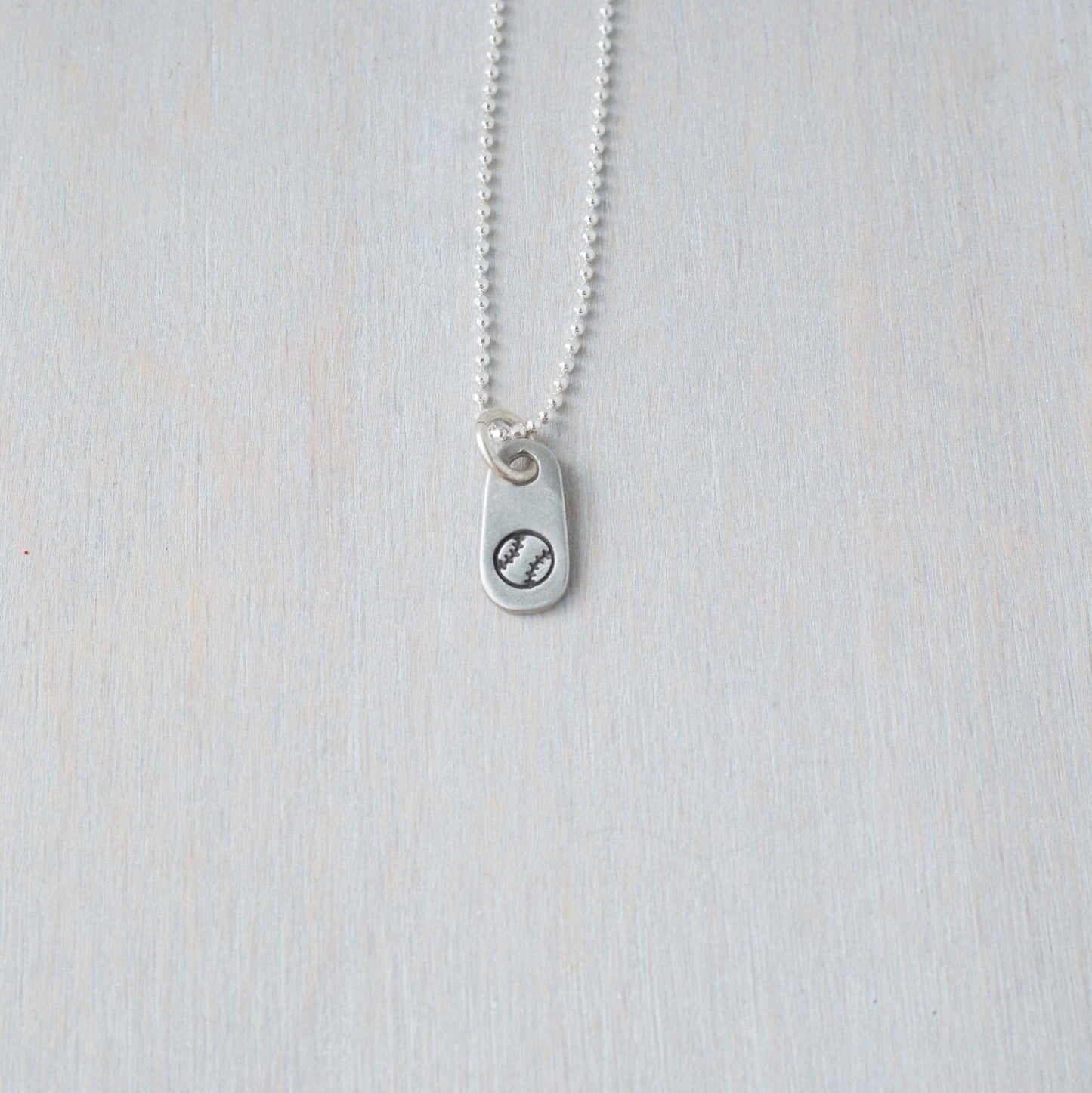 Silver softball necklace in artisan pewter