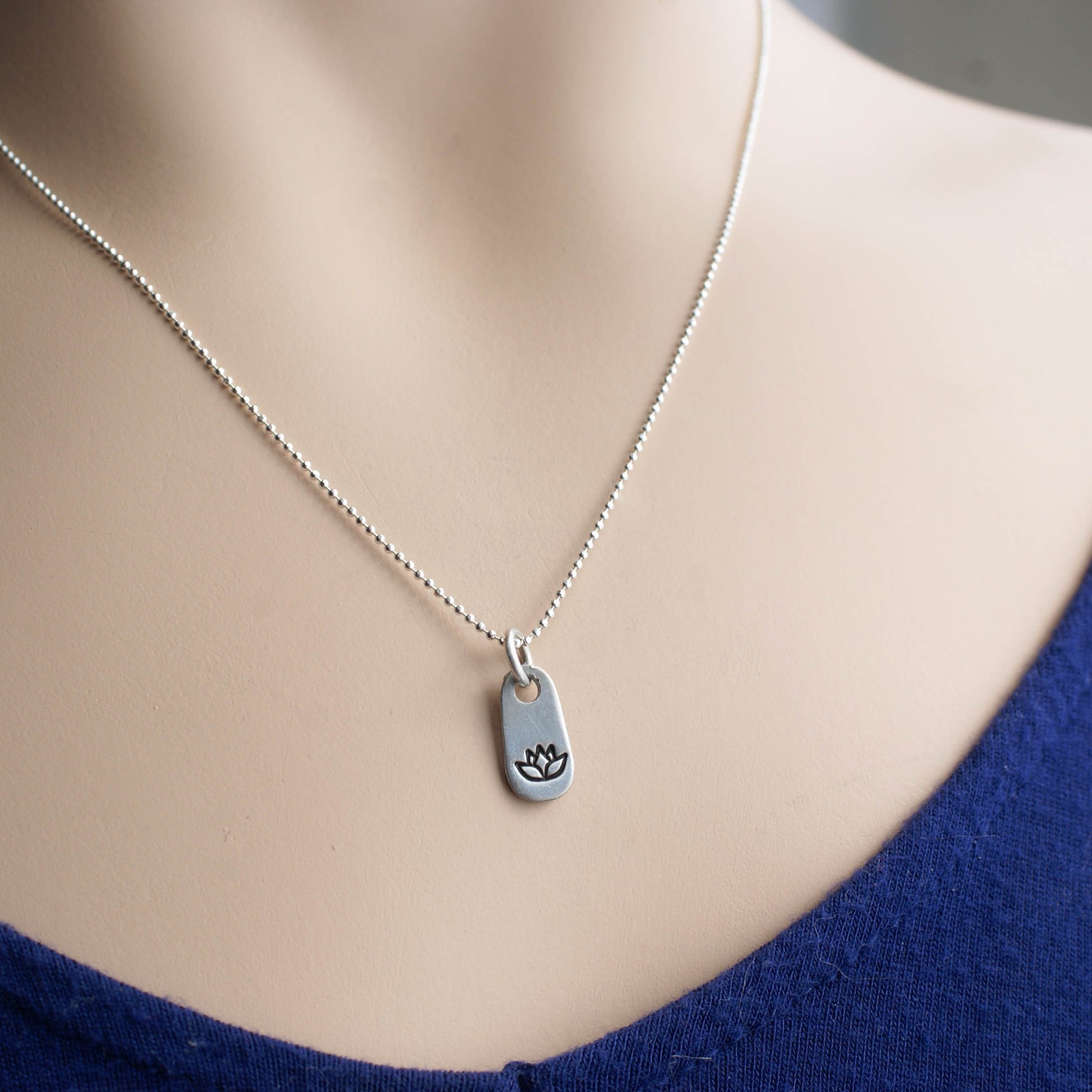 Silver lotus necklace in artisan pewter on neck