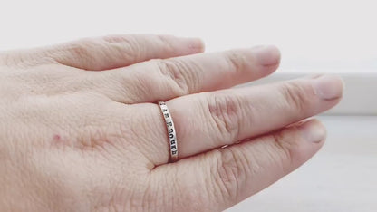Sterling Silver stacking ring handstmaped with I Am Enough on hand and being held