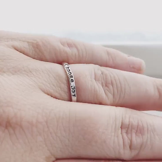 Handstamped choose joy ring in sterling silver on hand and being held
