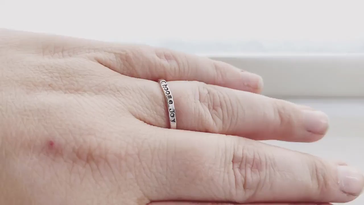 Handstamped choose joy ring in sterling silver on hand and being held