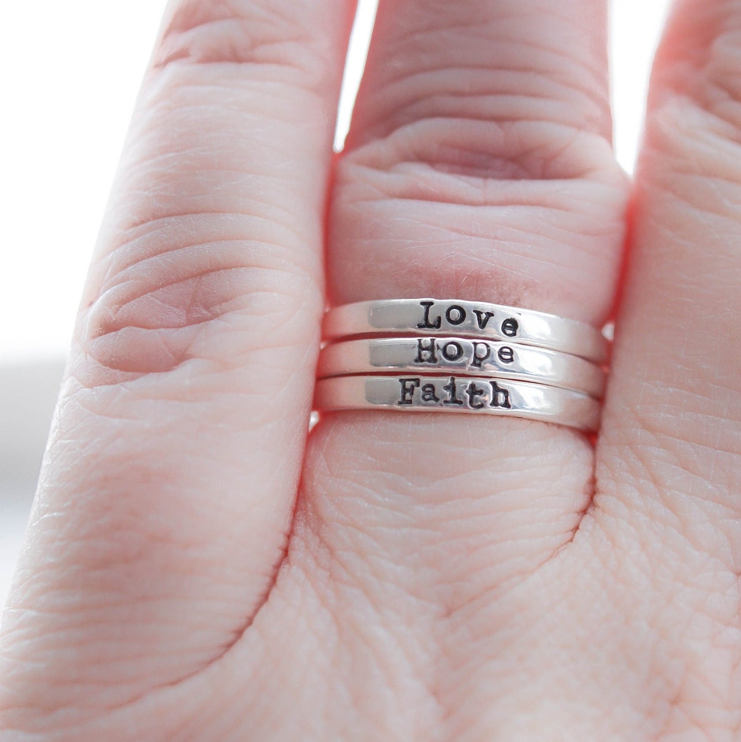 3 Sterling silver rings stamped with Faith, hope and love on hand