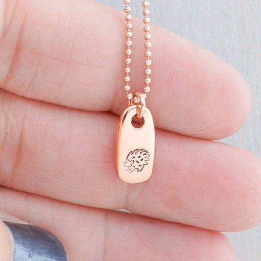 Rose gold hedgehog necklace in hand