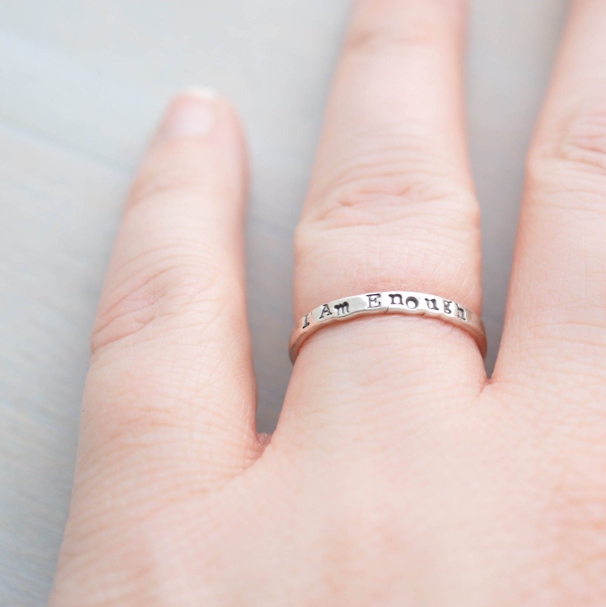 Sterling Silver stacking ring handstmaped with I Am Enough on hand