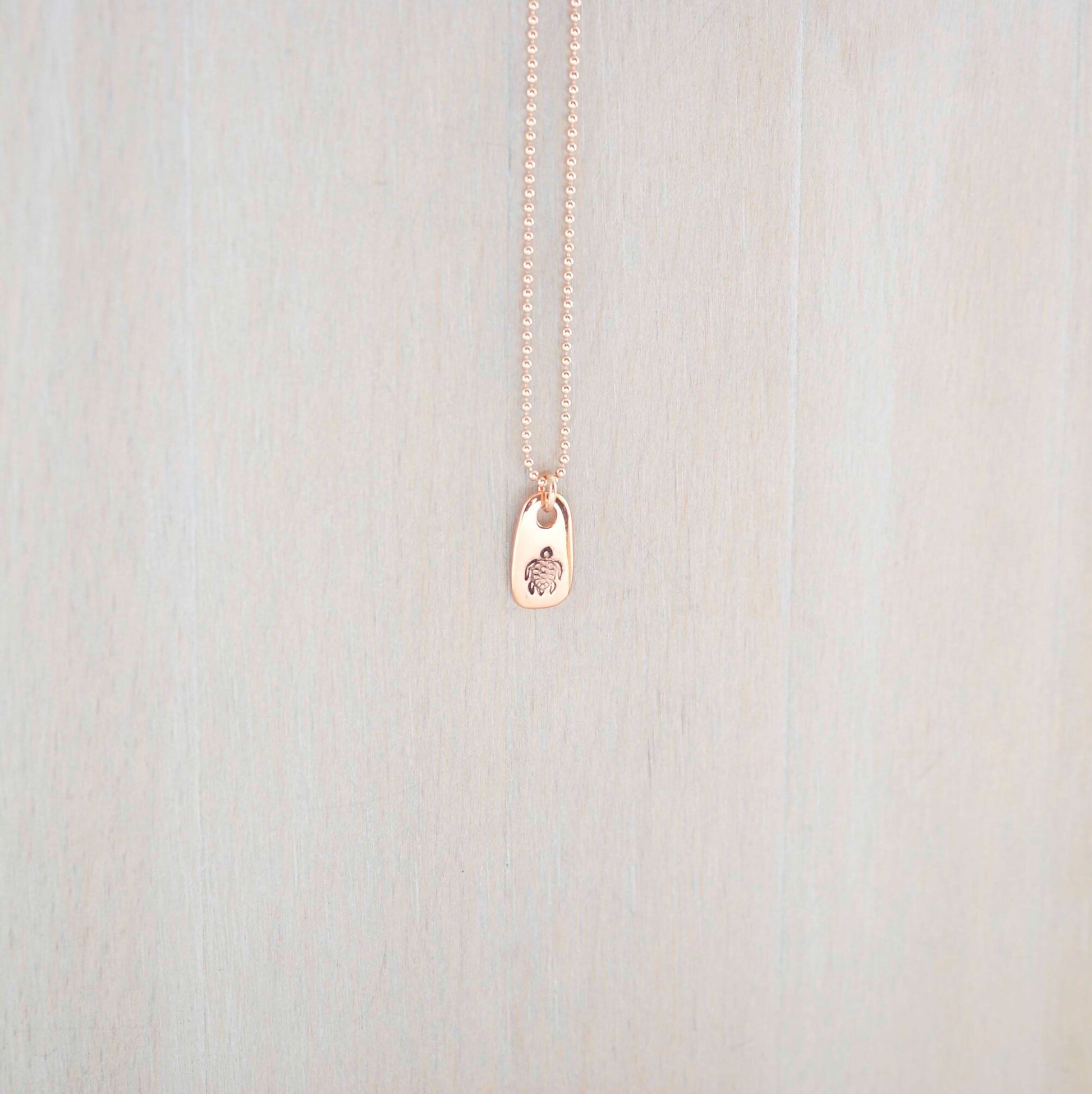 Rose gold necklace stamped with a turtle