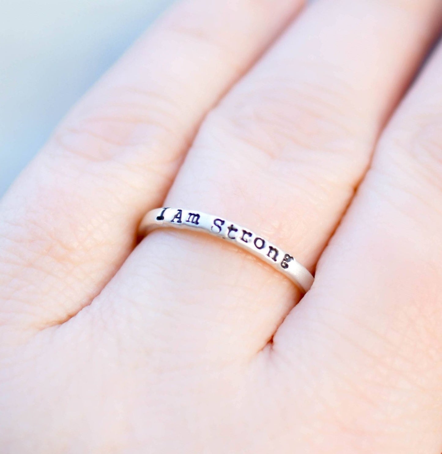 Sterling Silver stacking ring handstmaped with I Am Strong on hand