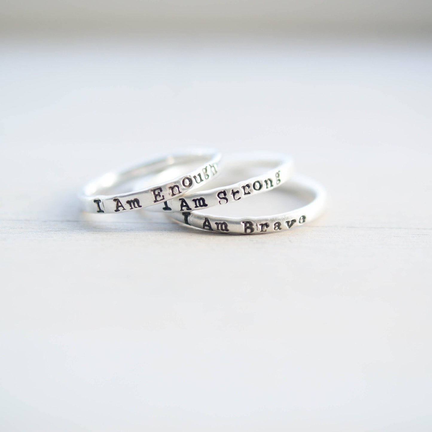 Three rings stacked, handstamped with I Am Enough, I Am Strong, I Am Brave
