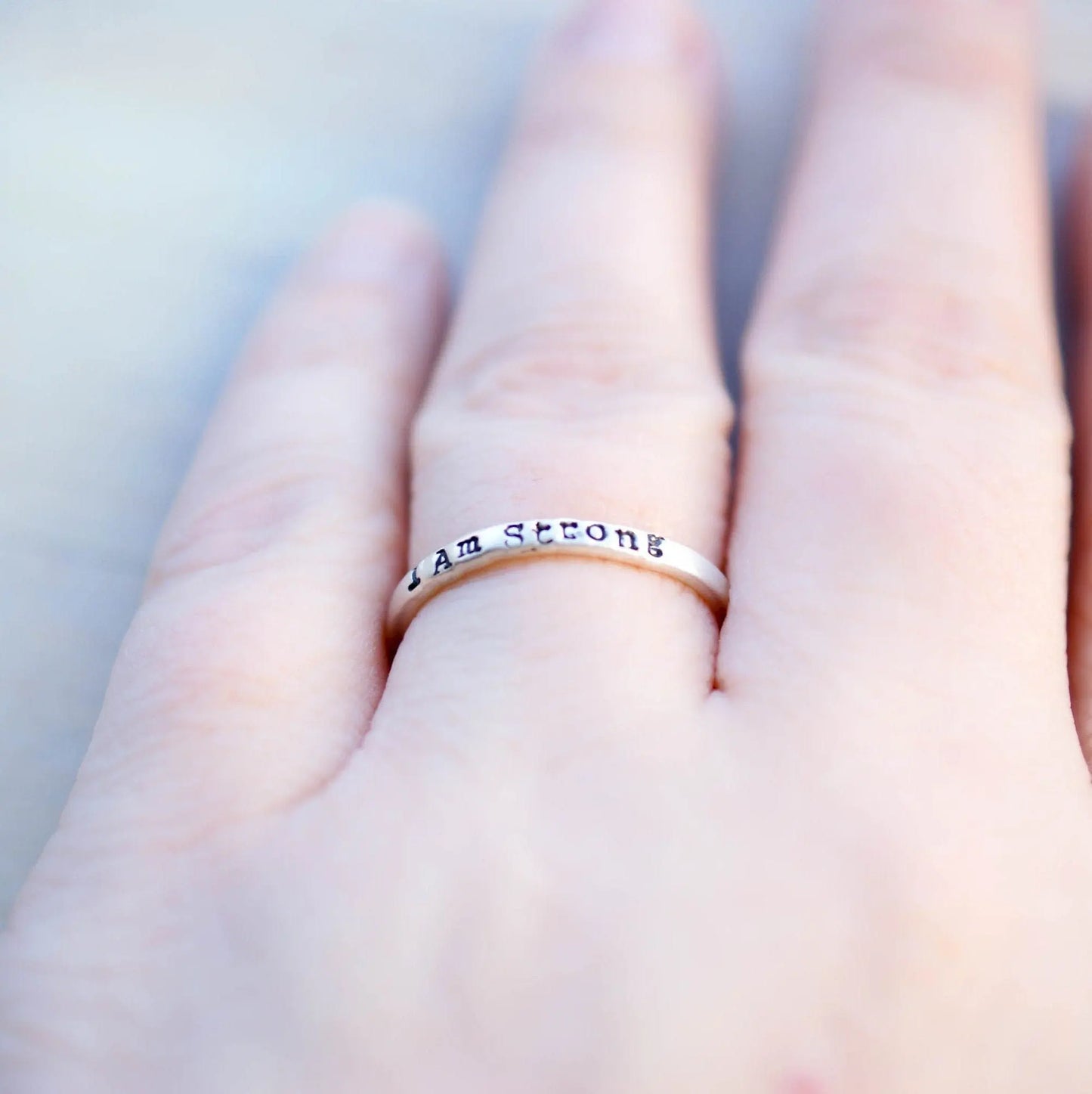 Sterling Silver stacking ring handstmaped with I Am Strong on hand