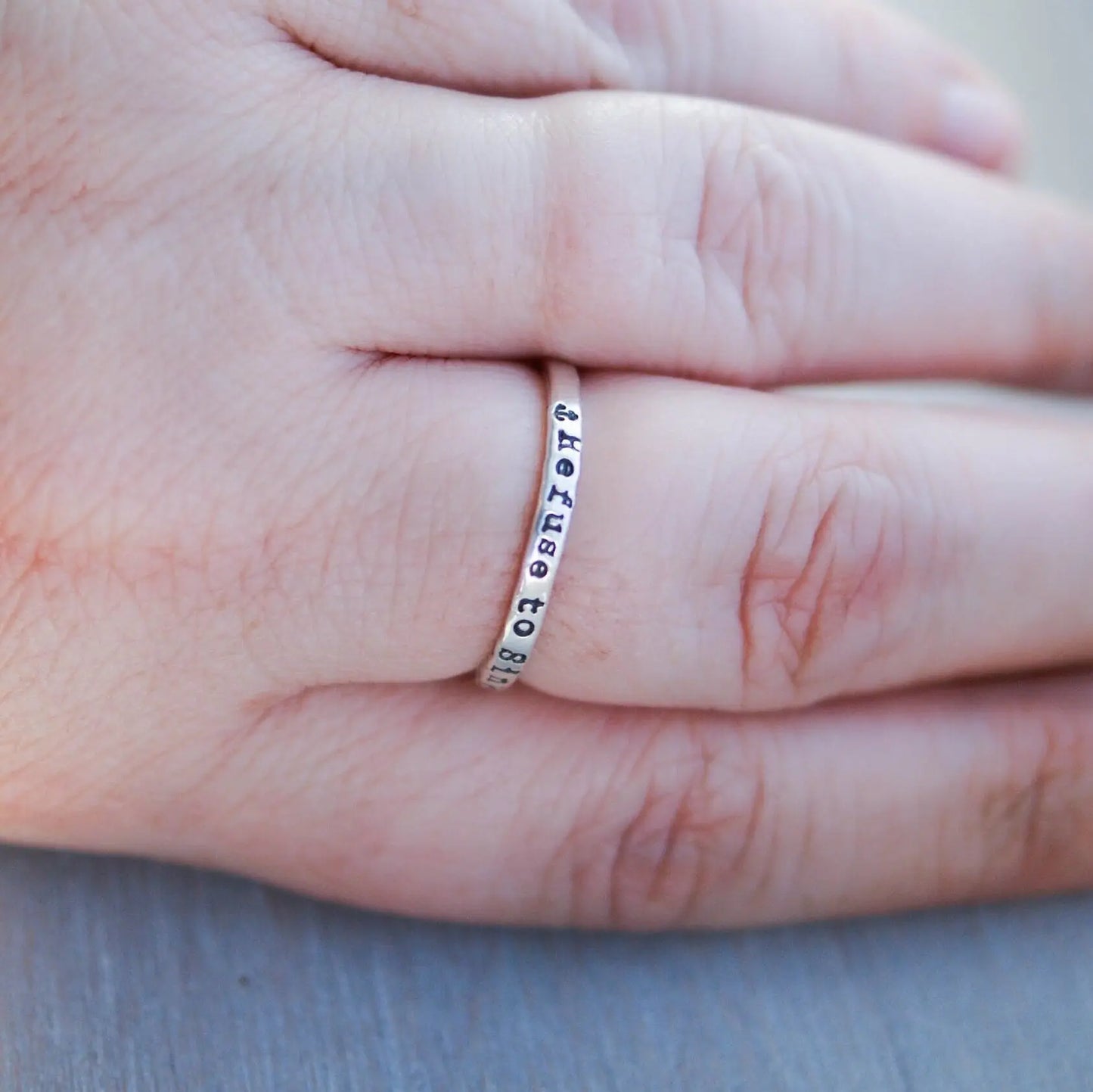 Sterling silver ring handstamped with Refuse to sink on hand