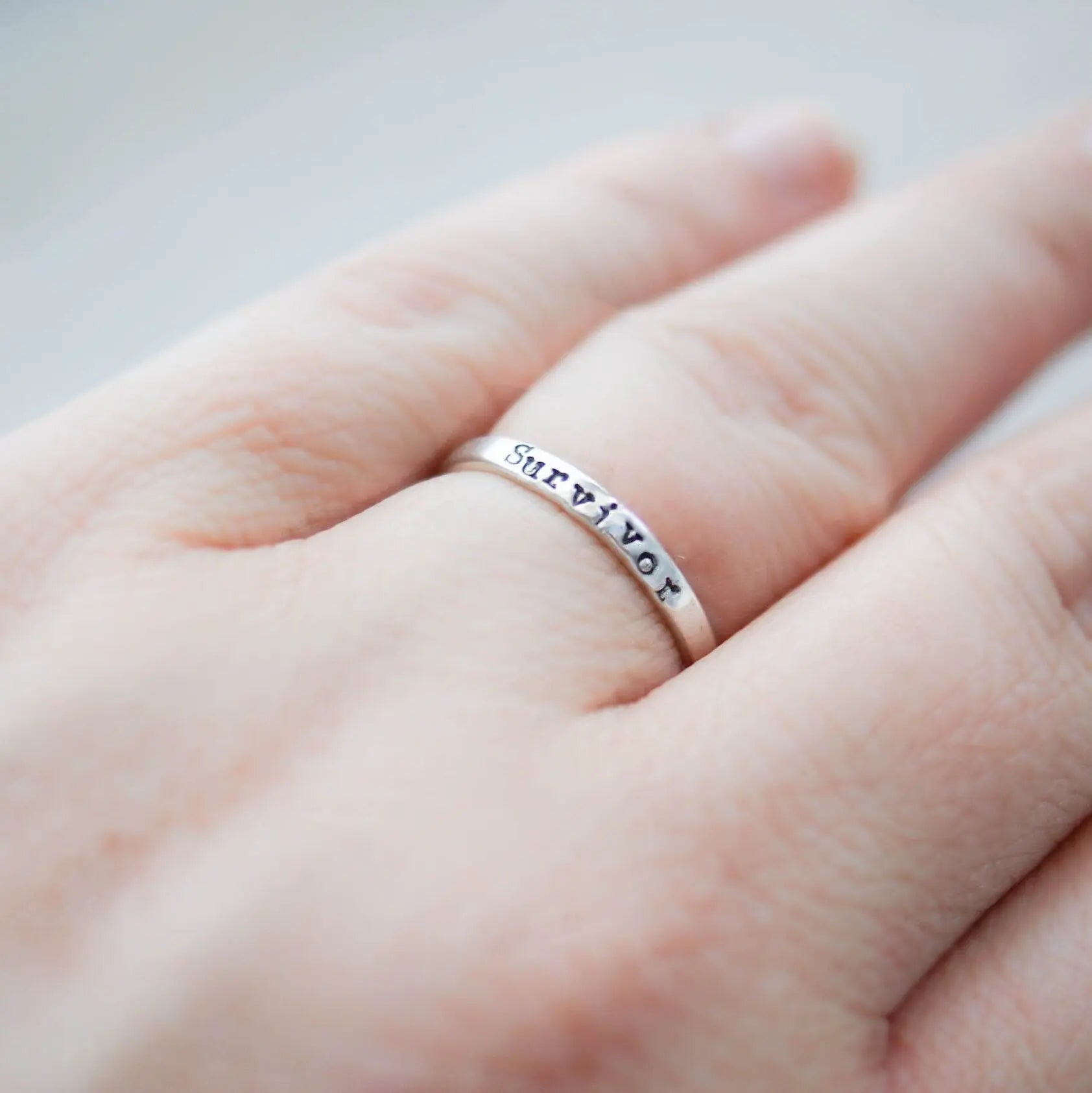 Sterling silver ring stamped with Survivor on hand