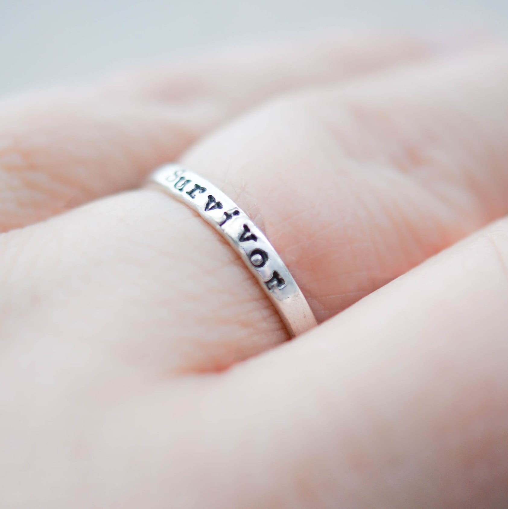 Sterling silver ring stamped with Survivor on hand