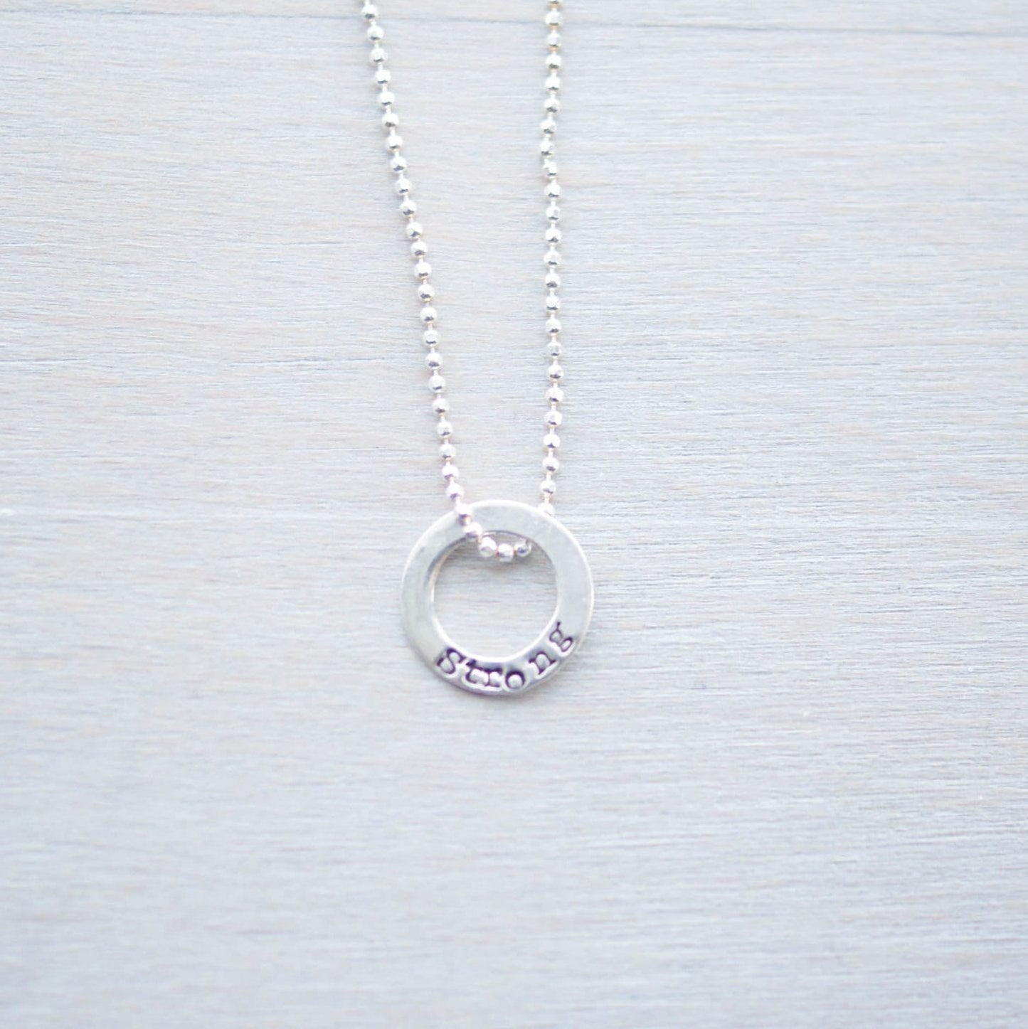 Sterling silver tiny circle stamped with Strong necklace