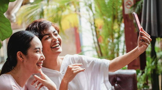 image of women laughing while taking selfies together