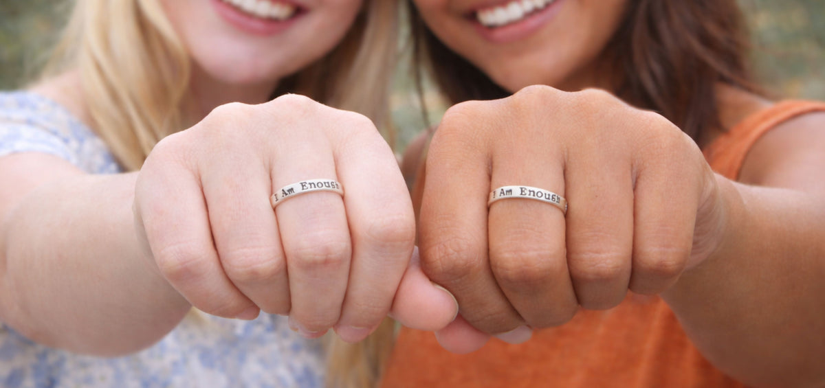 Two women wearing matching I Am Enough sterling silver rings