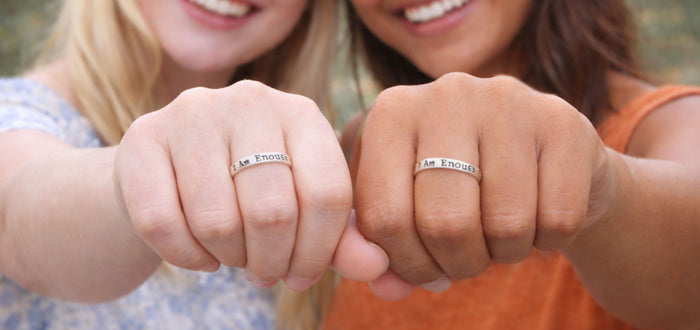 Two women wearing matching I Am Enough sterling silver rings