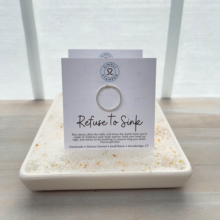 Image of ring on jewelry card that says Refuse to Sink