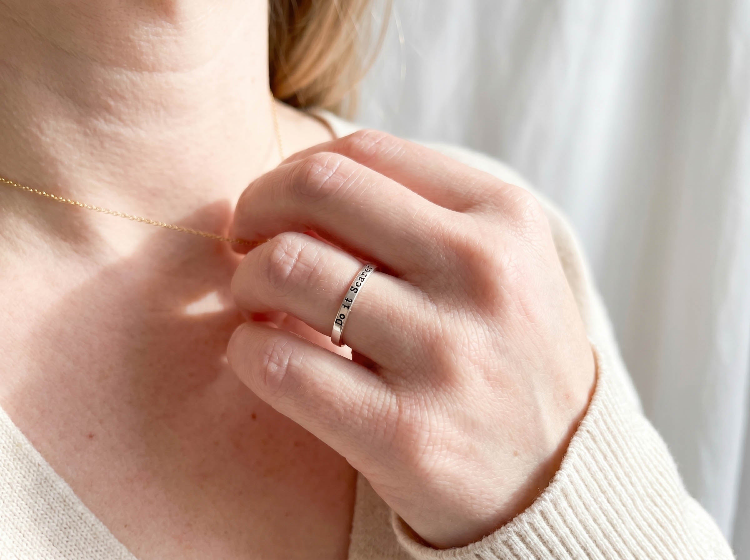Do it Scared Ring on hand holding necklace 