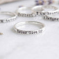 Sterling silver choose your words motivational ring on a white background with other rings behind