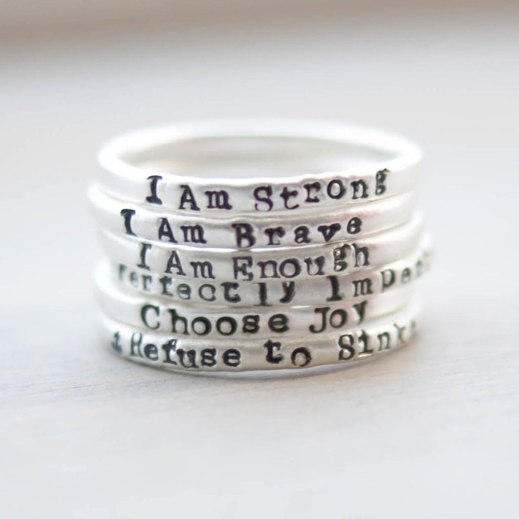 Stack of white rings with motivational phrases on a light background