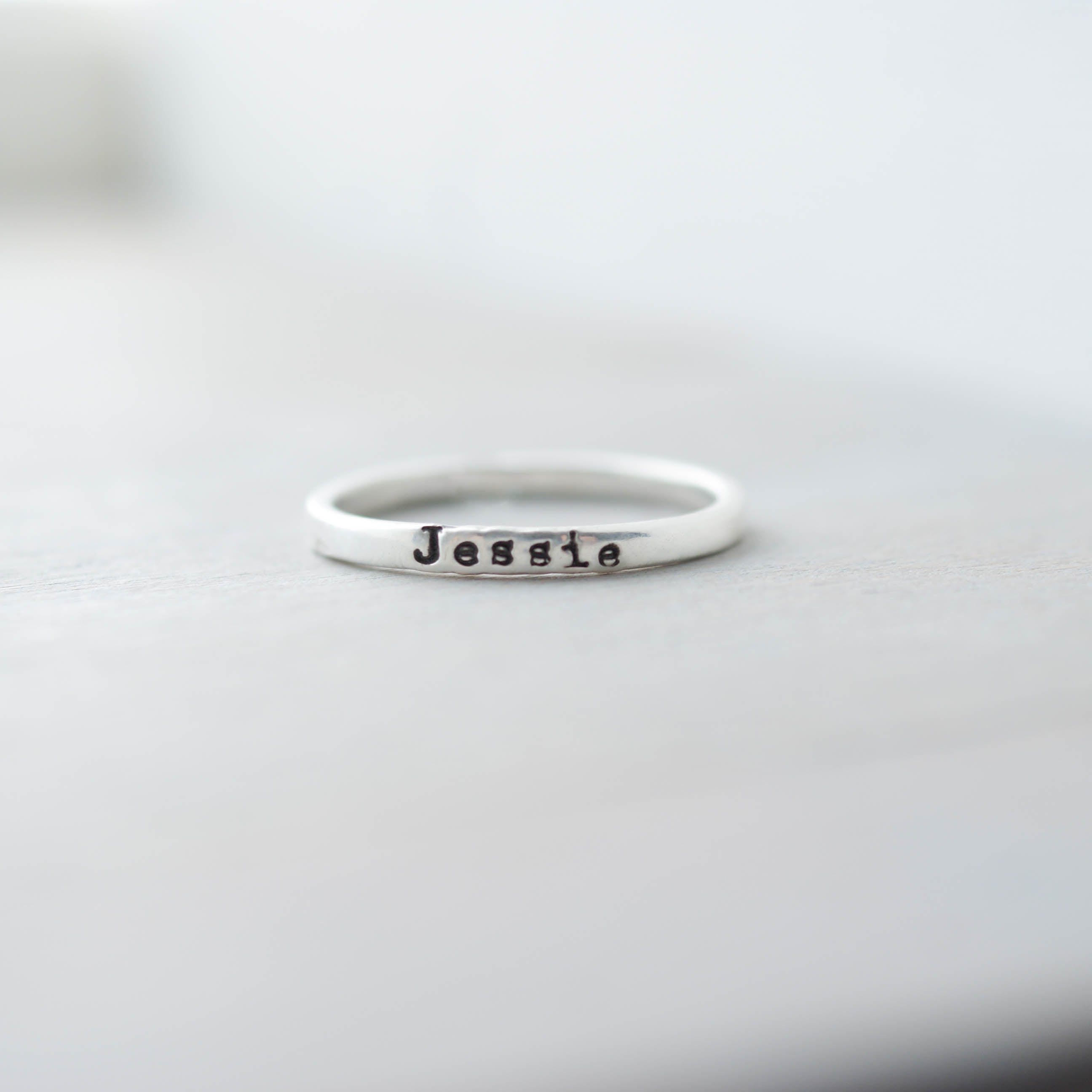 Sterling silver ring with 'Jessie' stamped on a light gray background