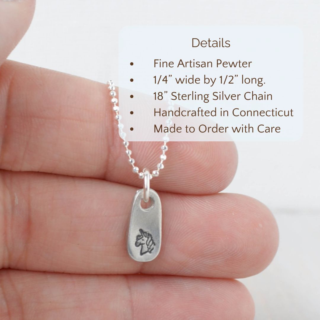 image of pewter unicorn necklace held in hand with detail text overlay