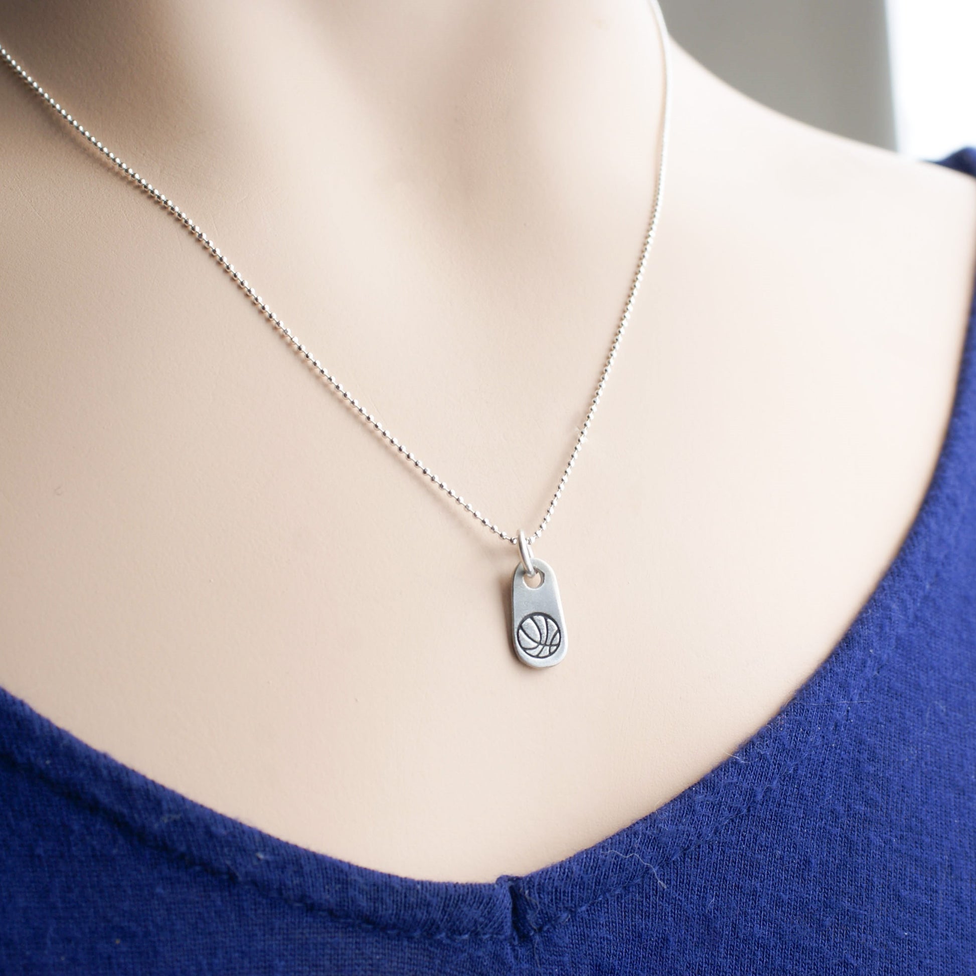 Silver basketball mom necklace in artisan pewter on neck