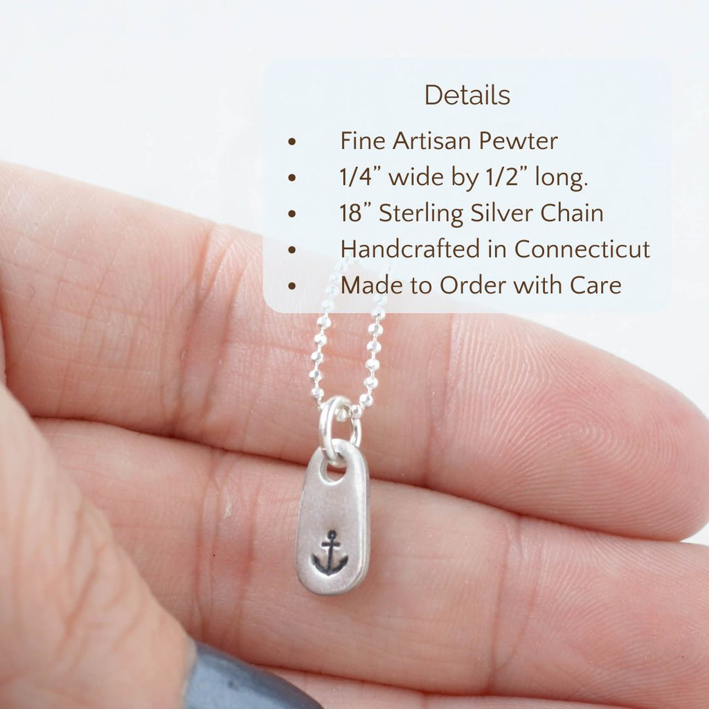 Image of anchor pendant necklace held in a hand with the product details overlayed. fine artisan pewter, 1/4 in wide x 1/2 in long, 18 in sterling silver chain, handcrafted in connecticut, made to order with care.