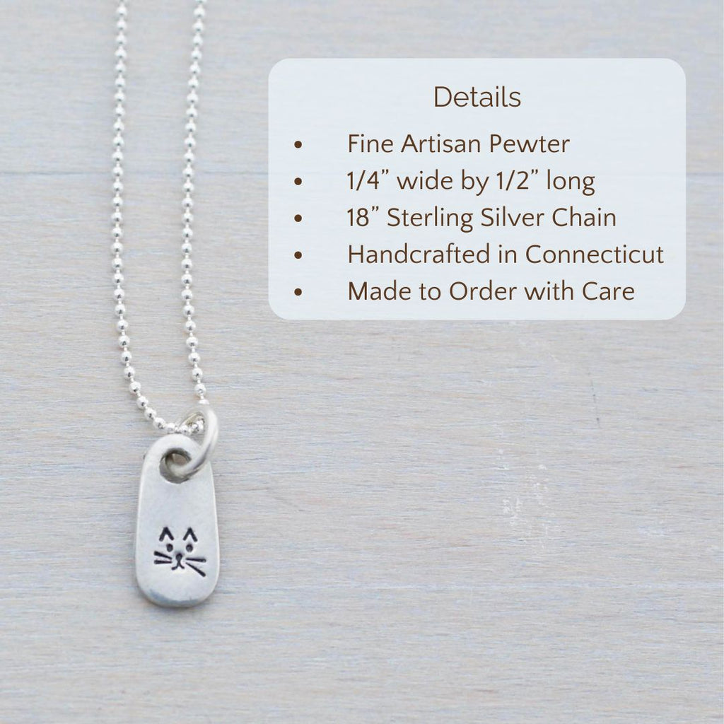 image of silver necklace with quirky cat face stamped on it. product details are overlayed. Fine Artisan Pewter, 1/4” wide by 1/2” long, 18” Sterling Silver Chain