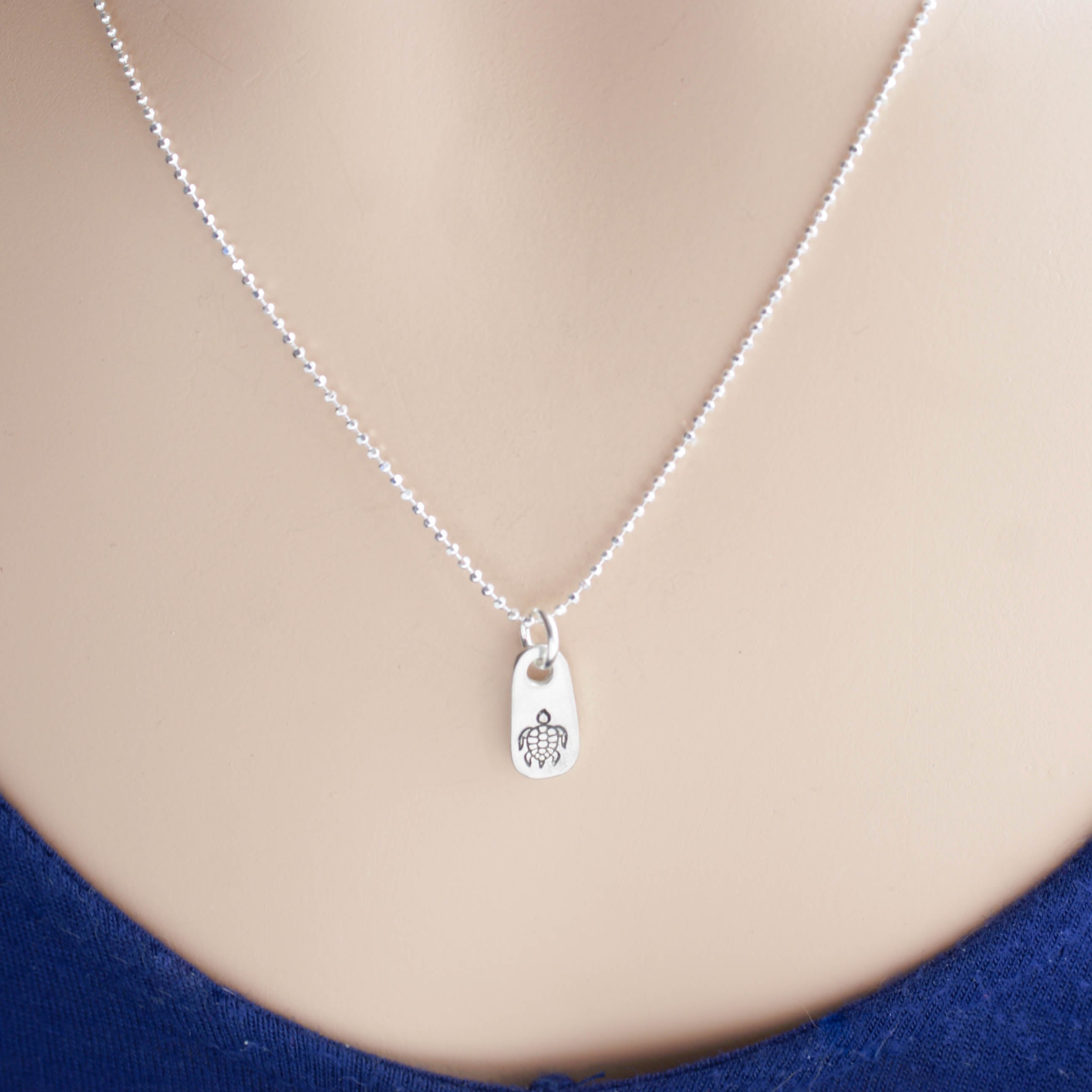 Silver sea turtle necklace in artisan pewter on neck