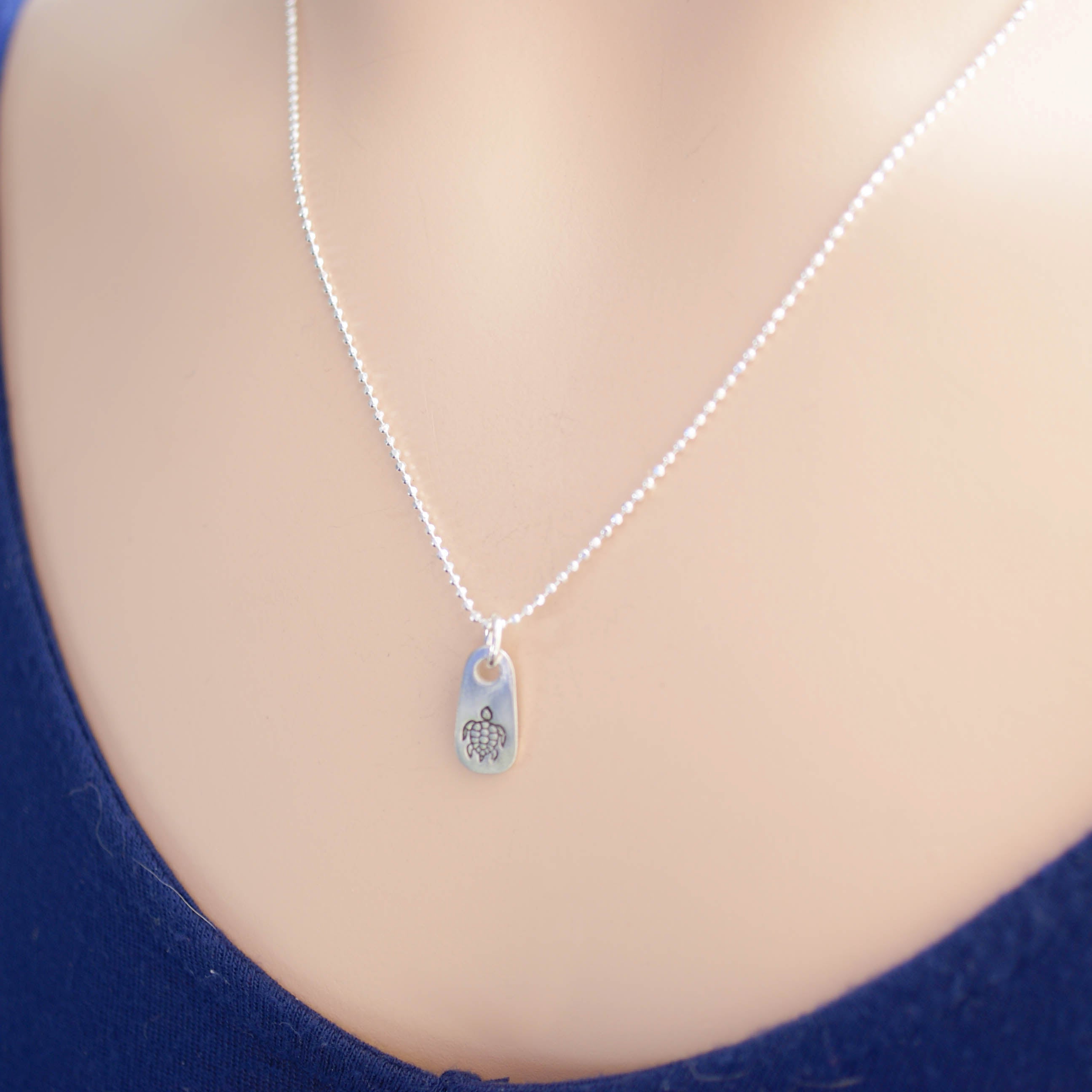 Silver sea turtle necklace in artisan pewter on neck