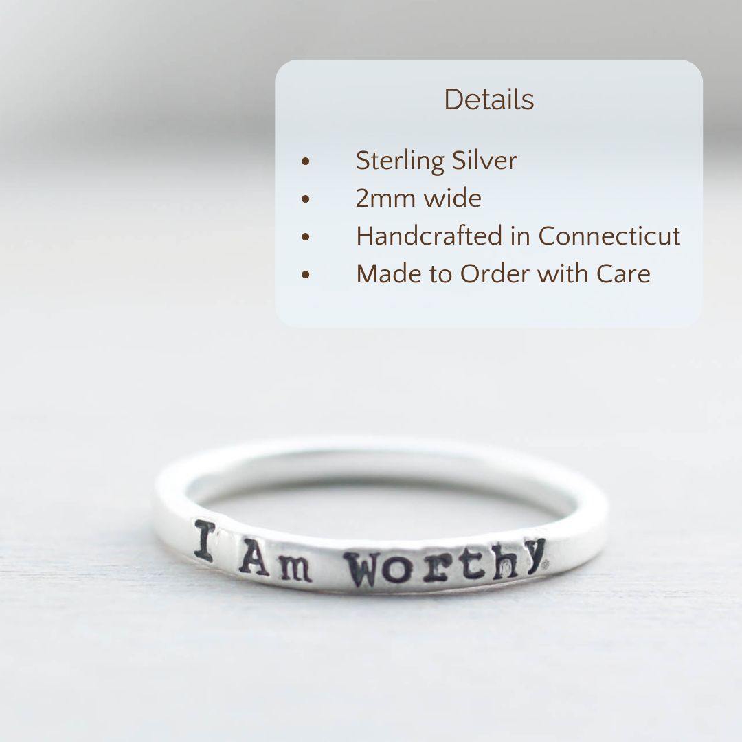 Image of I Am Worthy ring stamped on a hand with the product details overlayed. Sterling silver, 2mm wide, handcrafted in connecticut, made to order with care.