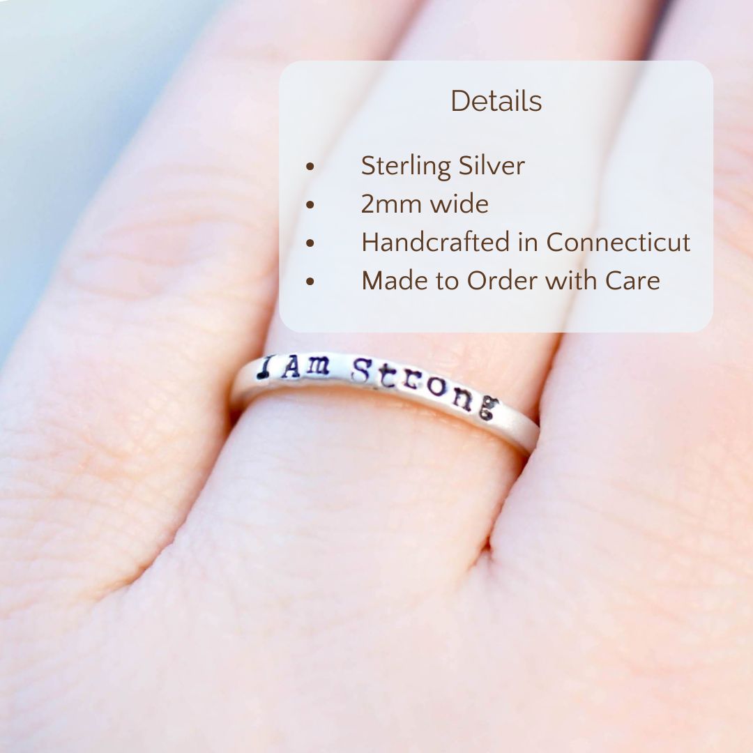 image of silver ring on hand stamped with I Am Strong with product details overlayed Sterling Silver, 2mm wide