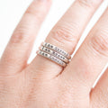 Three slim silver rings stacked on a finger, each engraved with the phrase 'I Am Strong', 'I Am Brave', and 'I Am Enough' in a serif font.