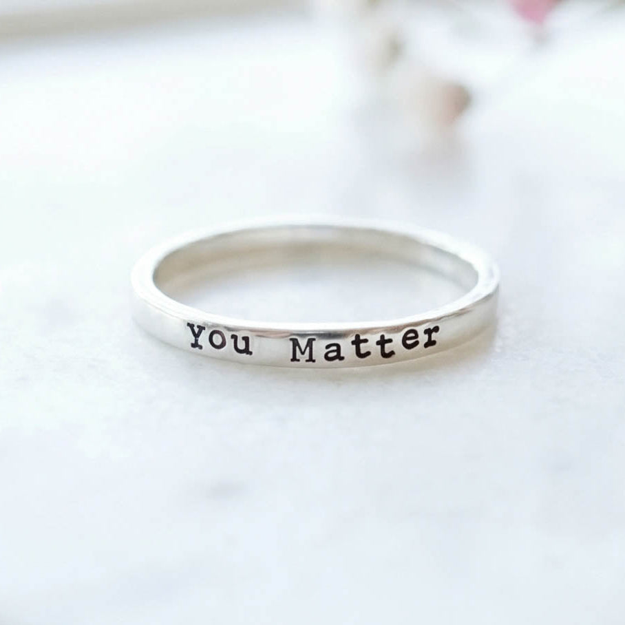 Silver ring with 'You Matter' stamped on a white background