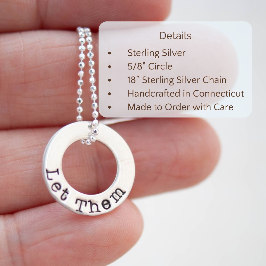 image of sterling silver washer necklace stamped with Let Them held in a hand with product details overlayed. Sterling silver, 5/8" circle, 18" sterling silver chain