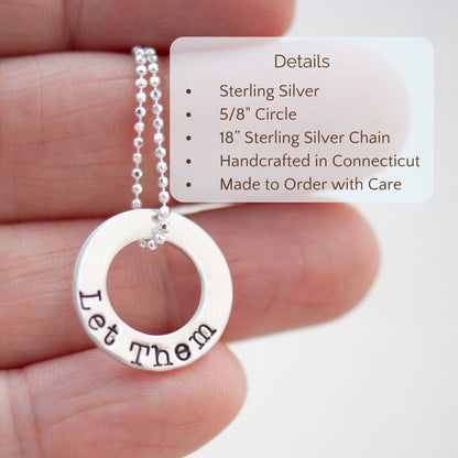 image of sterling silver washer necklace stamped with Let Them held in a hand with product details overlayed. Sterling silver, 5/8" circle, 18" sterling silver chain