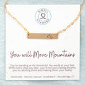 mage of gold necklace with mountain stamped on the right side on card with motivational card.