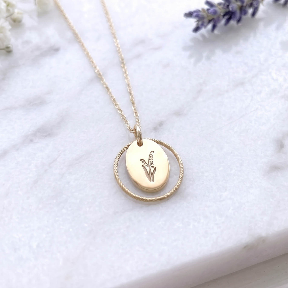 lily of the valley gold filled july birth flower necklace on a marble surface