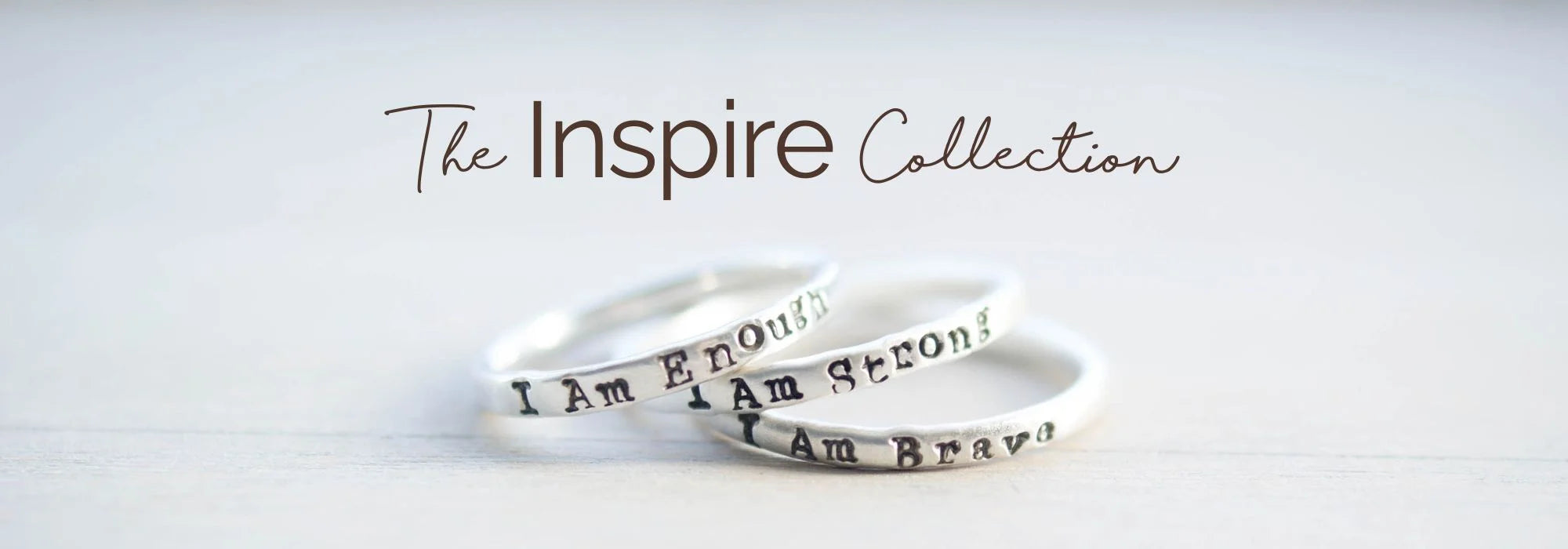 image of three sterling silver rings that say i am enough, i am strong, i am brave and above them says The Inspire Collection