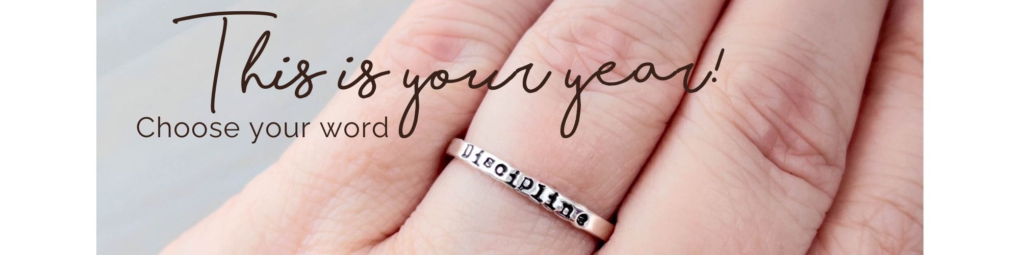 Silver ring with engraved "Discipline" on a hand, with text overlay 'This is your year. Choose your word.'