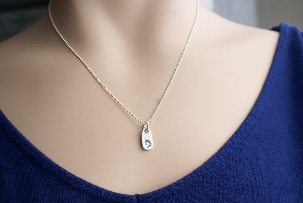 Silver unicorn necklace in artisan pewter on neck