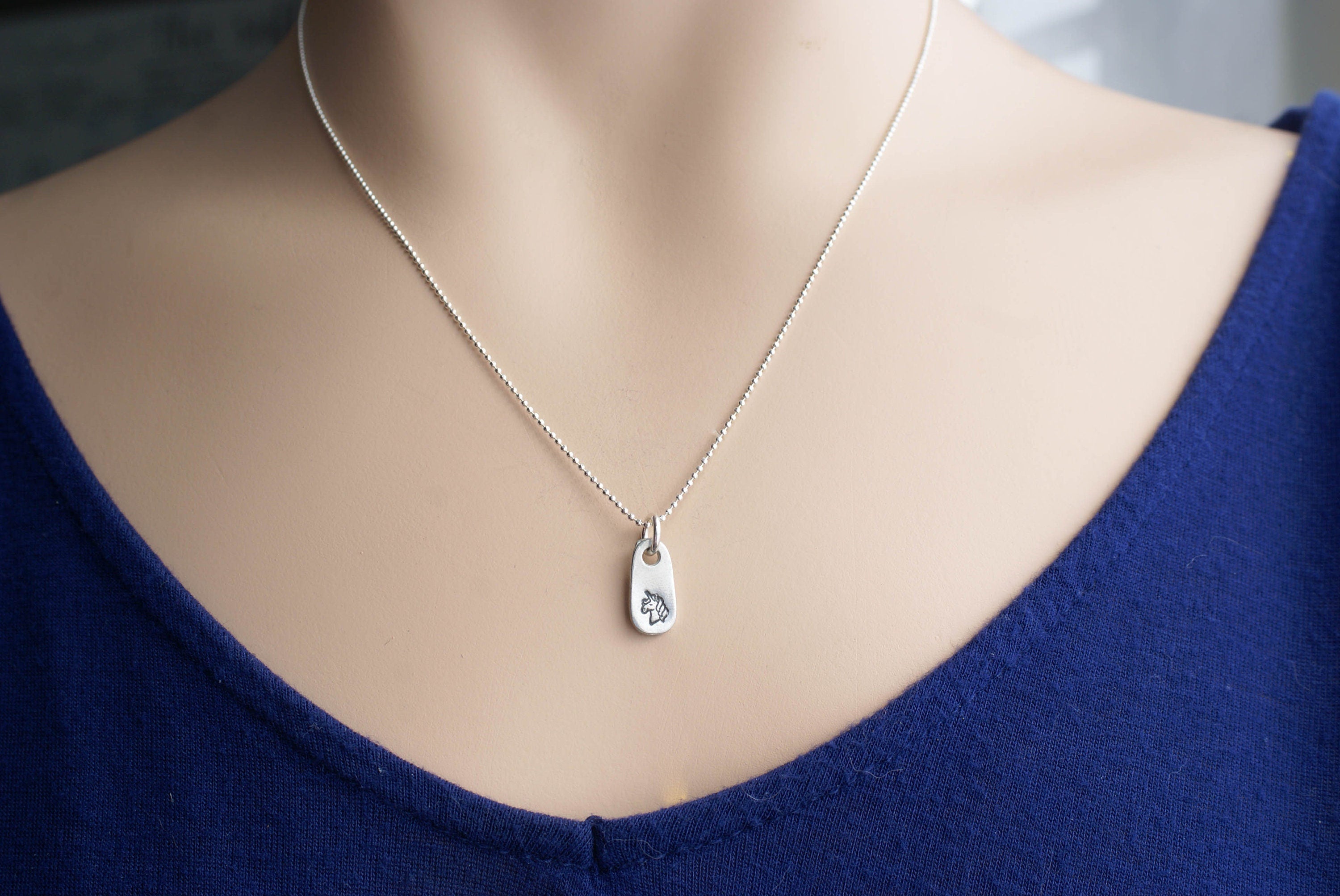 Silver unicorn necklace in artisan pewter on neck